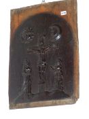 AN OAK PANEL CARVED IN RELIEF WITH CHRIST CROUCHED BELOW THE SUN AND MOON WHILE TWO SAINTLY LADIES