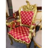 A GILTWOOD ARMCHAIR WITH SPREAD EAGLE CRESTED UPHOLSTERED BACK, A FOLIATE CARVED APRON TOP TO THE