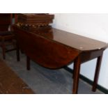 A GEO.III.STYLE MAHOGANY WAKE TABLE WITH GATE LEG DROP LEAVES ON MOULDED SQUARE LEGS. 178 x 130 x