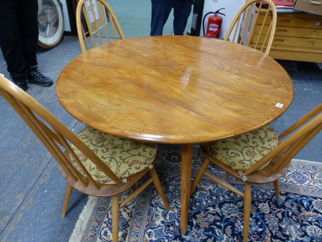 AN ERCOL PALE ELM DROP LEAF DINING TABLE AND A SET OF FOUR HIGH HOOP BACK DINING CHAIRS. (5)