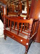 A MAHOGANY CANTERBURY WITH FOUR DIVISIONS AND CENTRAL PIERCED HANDHOLD ON RING TURNED TAPERED LEGS