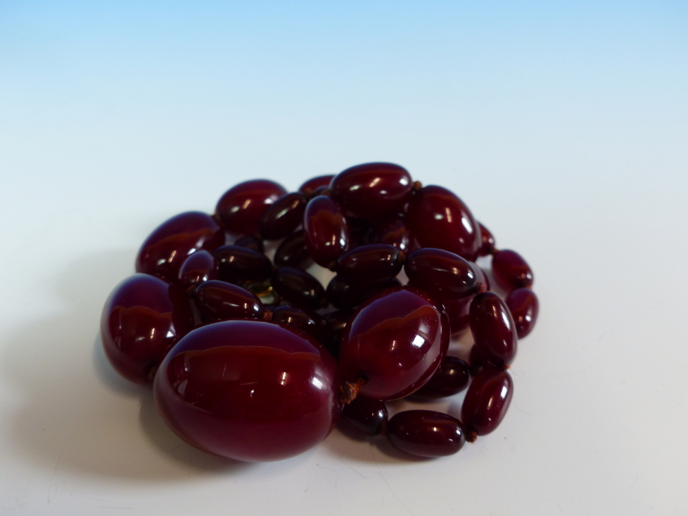 A GRADUATED ROW OF CHERRY AMBER BEADS, KNOTTED. LENGTH 76cms, WEIGHT 60 grams. - Image 16 of 21