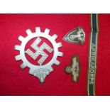 AN NSBO ALLOY BANNER TOP, AN AFRIKA KORPS CUFF TITLE AND TWO PIECES OF NSKK INSIGNIA. (4)