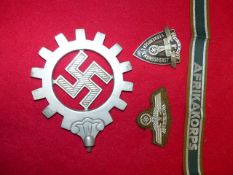 AN NSBO ALLOY BANNER TOP, AN AFRIKA KORPS CUFF TITLE AND TWO PIECES OF NSKK INSIGNIA. (4)