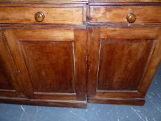 A VICTORIAN PINE AND FRUITWOOD BREAKFRONT CABINET WITH FOUR PANEL DOORS OVER THREE DRAWERS AND