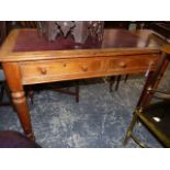 A RED LEATHER INSET OAK TWO DRAWER WRITING TABLE ON TURNED CYLINDRICAL LEGS TAPERING TO WHITE