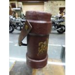 A BROWN CANVAS SHOT CARRIER PRINTED WITH THE ROYAL ARMS BELOW A SWING OVER LEATHER HANDLE. H.34cms.