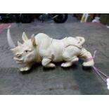 A JAPANESE IVORY CARVING OF A RHINOCEROS, SIGNED. W.13cms.