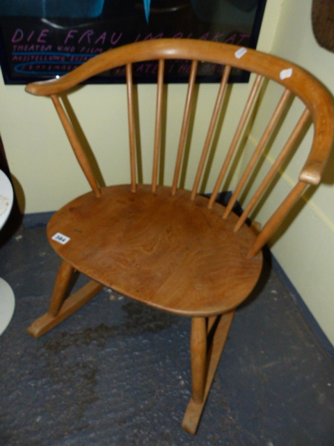 AN ERCOL PALE ELM COTTAGE SMALL ROCKING CHAIR WITH BS1960 STAMP.