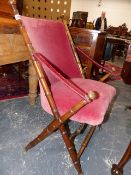 A PINK VELVET UPHOLSTERED MAHOGANY FOLDING CAMPAIGN TYPE CHAIR, THE SIMULATED BAMBOO POLES EITHER