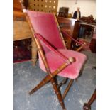 A PINK VELVET UPHOLSTERED MAHOGANY FOLDING CAMPAIGN TYPE CHAIR, THE SIMULATED BAMBOO POLES EITHER