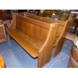 A PAIR OF OAK PEWS, THE ENDS WITH QUARTER ROUND ARMRESTS FLANKING THE PLANKED BACKS. 151 x 48 x H.