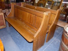 A PAIR OF OAK PEWS, THE ENDS WITH QUARTER ROUND ARMRESTS FLANKING THE PLANKED BACKS. 151 x 48 x H.