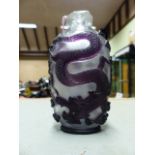 A CHINESE PURPLE OVERLAY CLEAR GLASS SNUFF BOTTLE DEPICTING DRAGONS. H.11.5cms.