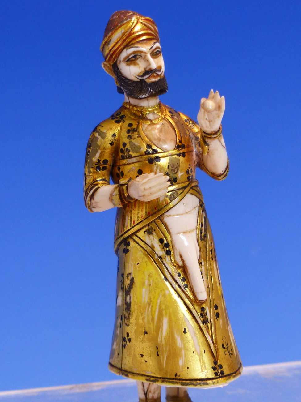 AN ANTIQUE MUGHAL GILT AND PAINTED IVORY FIGURE OF A PARTIALLY CLAD MAN STANDING HOLDING A POD - Image 3 of 13