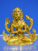 A TIBETAN GILT BRONZE FIGURE OF CHENREZIG, THE FOUR ARMED DEITY SEATED CROSS LEGGED. H.7cms.