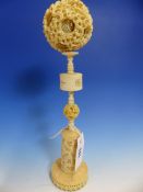 A CHINESE IVORY BALL WITHIN BALL CARVING WITH STAND, THE OUTER SKIN OF THE BALL CARVED WITH