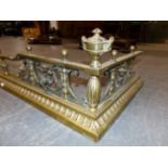 A LATE VICTORIAN BRASS FIRE FENDER DECORATED WITH CAST BRASS CHERUBS ON SWAG SWING. 158 x 43cms.