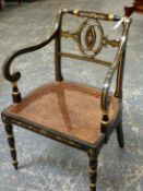 A REGENCY BLACK AND GOLD PAINTED ELBOW CHAIR, WHITE FLOWER HEADS ON THE TOP RAIL ABOVE THREE