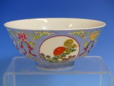 A CHINESE BOWL PAINTED WITH FAMILLE ROSE FLORAL ROUNDELS ON A LAVENDER BLUE GROUND INCISED WITH