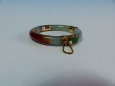 A 14K STAMPED GOLD MOUNTED JADE BANGLE FINISHED WITH A CARVED FISH, JADE AND PEARL CLASP COMPLETE