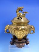 A CHINESE POLISHED BRONZE TRIPOD CENSER WITH ELEPHANT HEAD HANDLES AND DRAGON COVER FINIAL, WITH