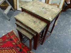 A NEST OF FOUR CHINESE CARVED AND POLYCHROME TABLES, EACH WITH LEATHER TOP DECORATED WITH FIGURES