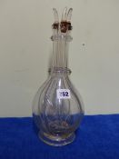 A GLASS FOUR COMPARTMENT DECANTER AND THREE STOPPERS, THE NECK OF THE BOTTLE SHAPE TRAILED WITH