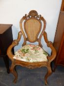 A PAIR OF VICTORIAN COLONIAL CARVED HARDWOOD ARMCHAIRS WITH CANE BACKS AND SEATS.
