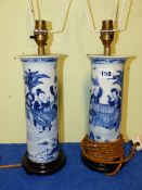 A PAIR OF CHINESE BLUE AND WHITE SLEEVE VASES MOUNTED AS TABLE LAMPS AND PAINTED WITH FIGURES BY A
