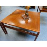 A MID CENTURY TEAK COFFEE TABLE, THE SQUARE TOP ON STRAP LEGS. W.74 x H.42.5cms.