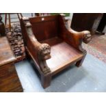 A PAIR OF CARVED OAK LOW STOOLS WITH LION FORM ARMS.