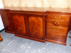 A BRIGHT'S OF NETTLEBED MAHOGANY BREAK FRONT SIDEBOARD, A LEATHER INSET SLIDE OVER CENTRAL DOORS