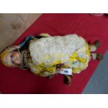 A BISQUE HEADED DOLL IN SUMPTIOUS MOORISH DRESS AND WEARING MULTIPLE STRINGS OF BEADS. H.64cms