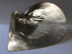 A VINTAGE DESK CLIP IN THE FORM OF A SILVER HALLMARKED WISH BONE MOUNTED ON A MOTHER OF PEARL SHELL,