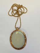 A 14k GOLD AND OPAL PENDANT WITH ADDITIONAL BROOCH FITTING, THE LARGE OVAL CUT OPAL SET IN A 14K