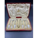 A CASED SET OF SIX SILVER GILT AND WHITE ENAMELLED NORWEGIAN TEASPOONS AND A PAIR OF SUGAR NIPS,