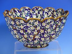 OTA, A JAPANESE CLOISONNE PETAL RIMMED BOWL WORKED WITH CHERRY BLOSSOMS ON A DEEP BLUE GROUND,