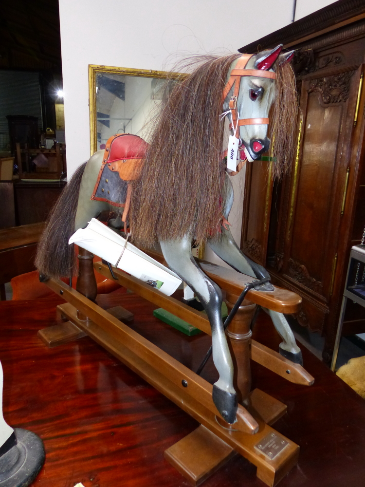 A STEVENSON BROTHERS DAPPLED GREY ROCKING HORSE WITH LEATHER BRIDLE AND RED SEATED SADDLE. H.95cms.