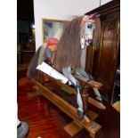 A STEVENSON BROTHERS DAPPLED GREY ROCKING HORSE WITH LEATHER BRIDLE AND RED SEATED SADDLE. H.95cms.