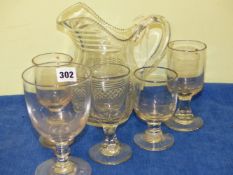 A CUT GLASS JUG TOGETHER WITH FIVE RUMMER STYLE GLASSES.