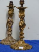 A PAIR OF GILT BRONZE ROCOCO CANDLESTICK LAMPS, THE NOZZLES ON BALUSTER STEMS OF TRIANGULAR