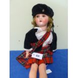 A SIMON AND HALBIG 1909-3 BISQUE HEADED DOLL WEARING KILT AND SPORRAN. H.64cms