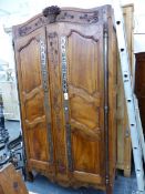 A FRENCH LOUIS XV WALNUT ARMOIRE WITH TWO SHAPED AND CARVED PANEL DOORS SUPPORTED ON FULL HEIGHT