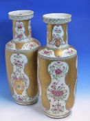 A PAIR OF SAMSON FAMILLE ROSE VASES PAINTED WITH VASES OF FLOWERS IN RESERVES BORDERED BY