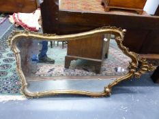 AN ANTIQUE OVAL GILT FRAMED WALL MIRROR WITH RIBBON CREST TOGETHER WITH A CARVED GILTWOOD FRAMED
