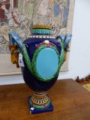 A BLUE GROUND MAJOLICA BALUSTER VASE, THE GOAT'S HEAD HANDLES HUNG WITH LAUREL SWAGS LINKED TO