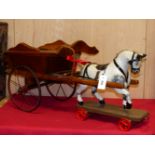 A PULL ALONG HANDMADE PIEBALD HORSE AND DOG CART BOTH WITH PAINTED METAL WHEELS. W.87cms