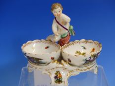 A BERLIN DOUBLE SWEETMEAT, THE BIRD PAINTED OVAL BOWLS SURMOUNTED BY A CENTRAL PUTTO. H.13cms.