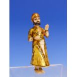 AN ANTIQUE MUGHAL GILT AND PAINTED IVORY FIGURE OF A PARTIALLY CLAD MAN STANDING HOLDING A POD